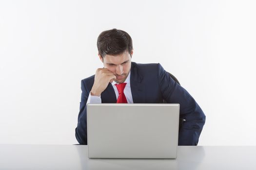 worried business executive in suit behind desk with laptop