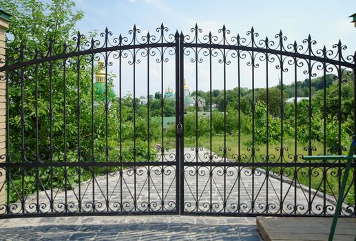 Golden domes of Kiev Pechersk Lavra Monastery in Kiev, Ukraine seen through the gate