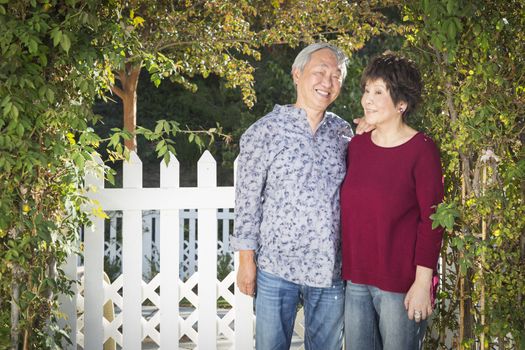 Attractive Happy Chinese Couple Enjoying Their House Outside.