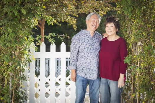 Attractive Happy Chinese Couple Enjoying Their House Outside.