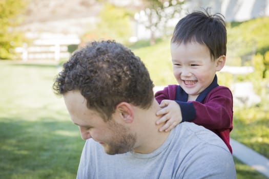 Happy Caucasian Father Having Fun with His Mixed Race Baby Son.