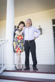 Attractive Happy Chinese Couple Enjoying Their House Outside.