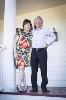 Attractive Happy Chinese Couple Enjoying Their House Outside.