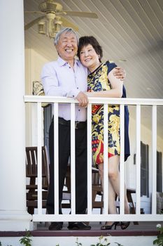 Attractive Happy Chinese Couple Enjoying Their House Outside.