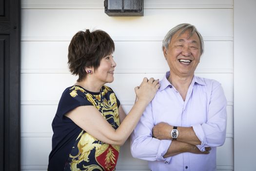 Attractive Happy Chinese Couple Enjoying Their House Outside.