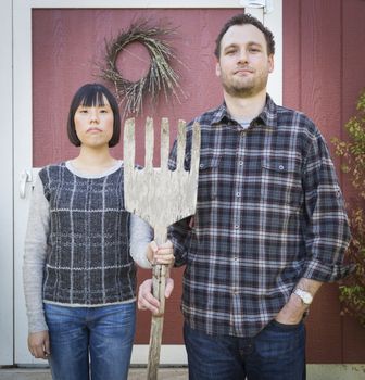 Fun Mixed Race Couple Portrait Simulating the American Gothic Painting by Grant Wood.