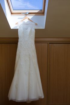 wedding dress hanging on window at hotel room