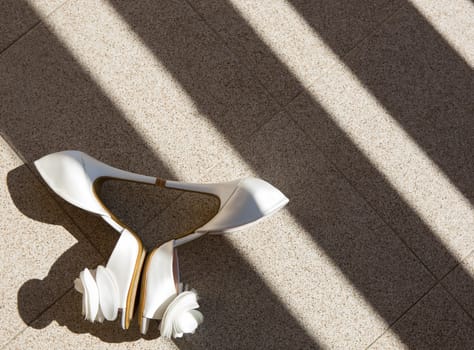 white wedding shoes with a bow . Close up