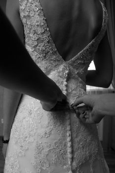 Helping the bride to put her wedding dress on