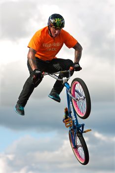 Hampton, GA, USA - September 27, 2014:  A young man with the High Roller BMX club rotates his bike in midair while performing a BMX stunt at the Georgia State Fair.