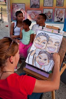 Hampton, GA, USA - September 27, 2014:  An artist draws a caricature portrait of a family at the Georgia State Fair. 