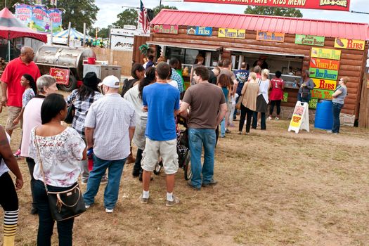 Hampton, GA, USA - September 27, 2014:  People wait in long line to order food from a concessions vendor at the Georgia State Fair. 