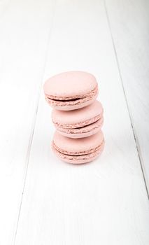 Set of macarons isolated on white wooden table