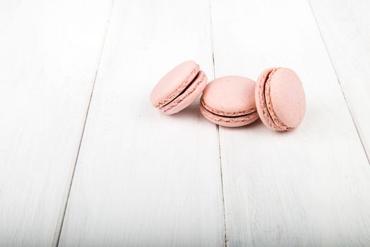 Set of macarons isolated on white wooden table
