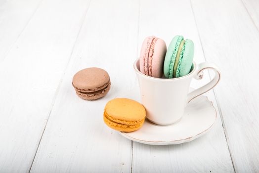 Set of macarons isolated on white wooden table