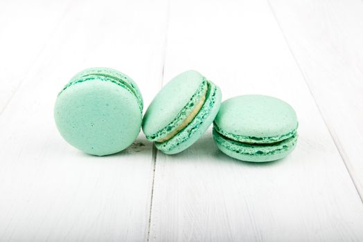 Set of macarons isolated on white wooden table