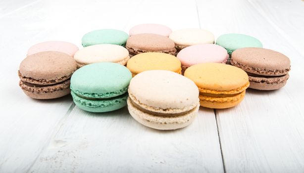 Set of macarons isolated on white wooden table