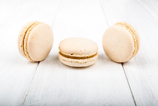 Set of macarons isolated on white wooden table