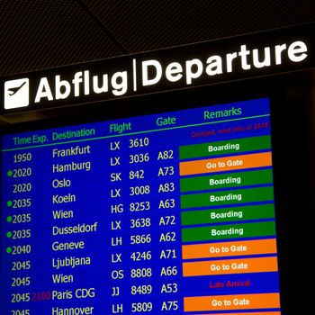 Airport departure board in terminal with flight information