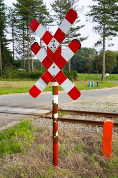 Red and white railroad crossing sign and road