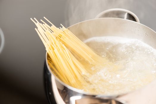 Spaghetti in pan cooking in boiling water