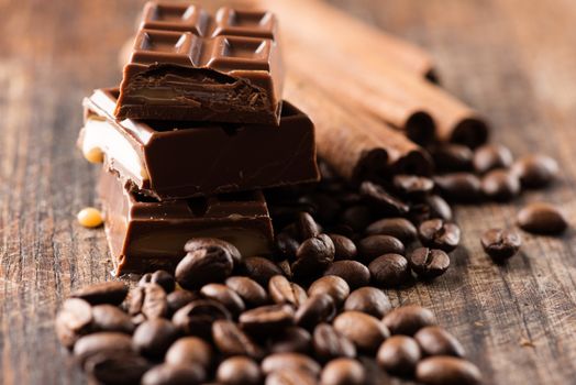 Coffee beans with chocolate bar on wooden table