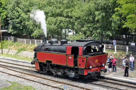 The steam locomotive tourist train from Anduze receding to hang cars and from Saint-Jean-du-Gard.