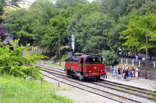 The steam locomotive tourist train from Anduze receding to hang cars and from Saint-Jean-du-Gard.