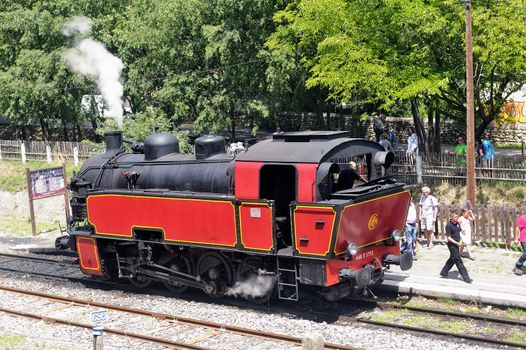 The steam locomotive tourist train from Anduze receding to hang cars and from Saint-Jean-du-Gard.