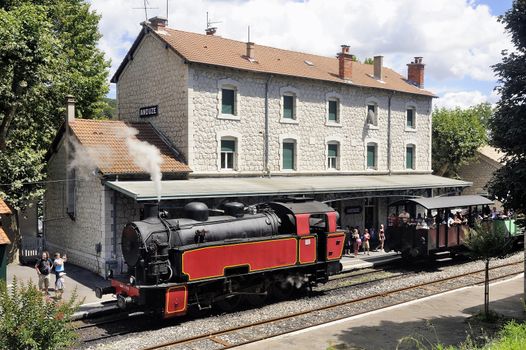 The steam locomotive tourist train from Anduze receding to hang cars and from Saint-Jean-du-Gard.