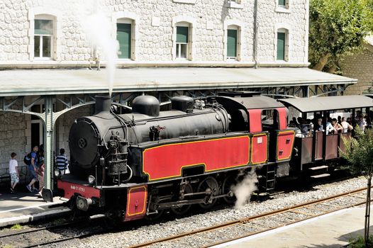 The steam locomotive tourist train from Anduze receding to hang cars and from Saint-Jean-du-Gard.