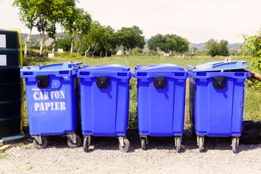 Recycling bins for paper and cardboard on the side of the road in the French department of Gard.