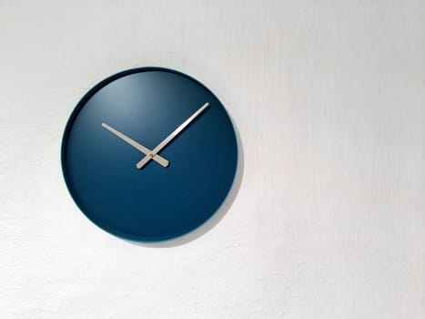 Blue clock on white wall. Modern decor.