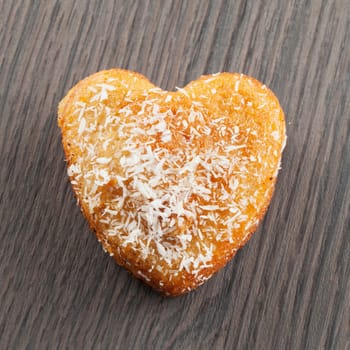Heart biscuit over wooden table, square image