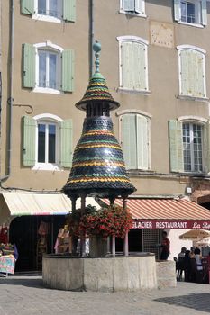 Old fountain with colorful tiles in Anduze pedestrian