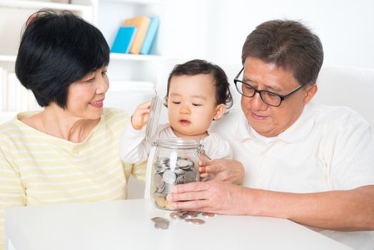 Asian family saving money indoor, grandparents and grandchild living lifestyle at home, financial concept.