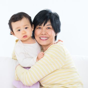 Asian family portrait, grandma and grandchild indoor living lifestyle at home.