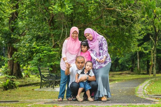 Happy Southeast Asian family outdoor lifestyle at nature green park.
