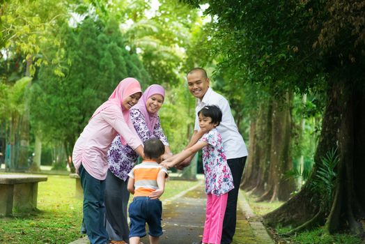 Happy family playing at outdoor garden park. Southeast Asian people living lifestyle.