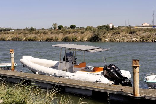 Small motor boat dock waiting to go out for a walk along the canal Le Grau-du-Roi in the Camargue