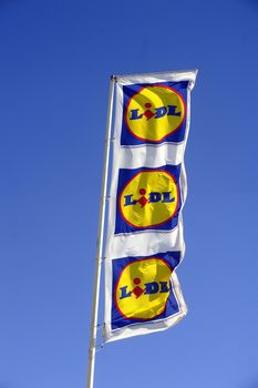 Flags in the colors of Lidl supermarket on the port of Grau-du-Roi windy day