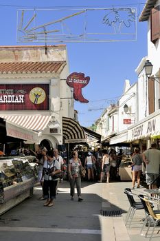 Walk through a pedestrian shopping street of Saintes-Maries-de-la-Mer in full summer.