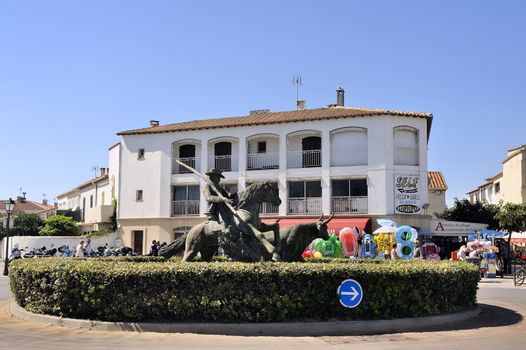 Statue of Guardian guiding a bull on the roundabout to the city center Camarguaise city of Saintes-Maries-de-la-Mer.