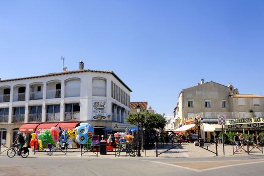 Town center of Saintes-Maries-de-la-Mer with the entrance to the pedestrian shopping streets and during the summer season.