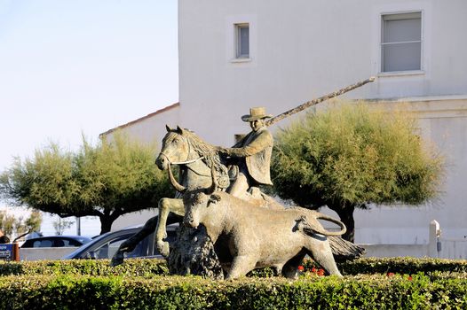 Statue of Guardian guiding a bull on the roundabout to the city center Camarguaise city of Saintes-Maries-de-la-Mer.