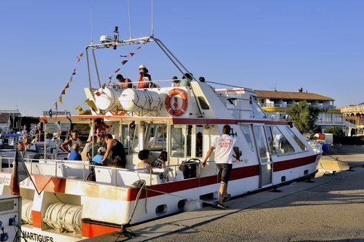 Sightseeing boat in the Sea of Saintes-Maries-de-la-Mer returning to port to unload its passengers.