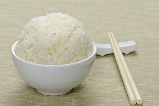 White steamed rice in ceramic bowl and chopsticks 