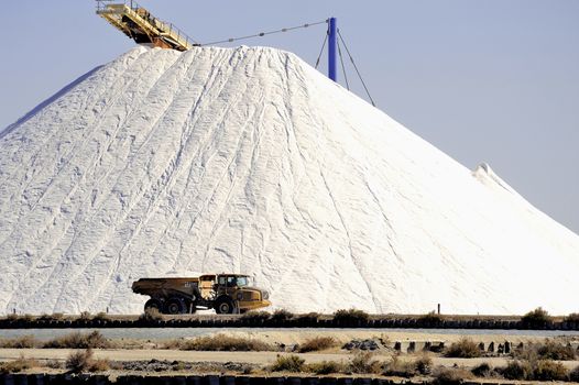 Site operating sea salt saline Aigues-Mortes with big machines and trucks working for the salt storage