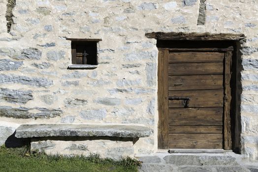 Wooden door, window and bench of the house