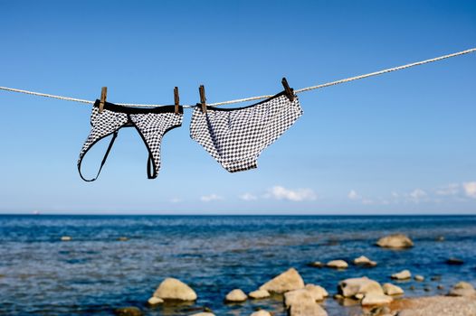 Swimsuit hanging on a rope on the sea beach